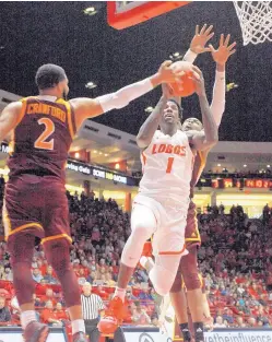  ?? GREG SORBER/JOURNAL ?? ABOVE: New Mexico’s Corey Manigault (1) takes aim at the basket as Iona’s E.J. Crawford defends. Manigault scored 20 points to lead UNM.