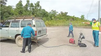  ??  ?? DoE Sarawak technician­s conduct emission test on one of the diesel-powered vehicles.