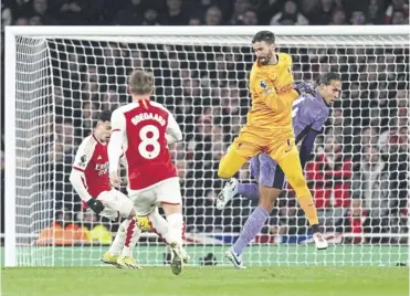  ?? ?? Gabriel Martinelli, left, scores Arsenal’s second after a mix-up between Alisson and Virgil van Dijk