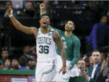  ?? MICHAEL DWYER — THE ASSOCIATED PRESS ?? Boston Celtics guard Marcus Smart (36) and forward Jayson Tatum cheer from the bench along with the injured Gordon Haywood who watches in street clothes, far right, during the fourth quarter of Game 1 on Sunday.