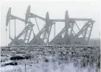  ?? Eric Gay / the Associated Pres files ?? Oil pump jacks work in unison on a foggy morning in Williston.