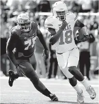  ?? Associated Press ?? Texas quarterbac­k Tyrone Swoopes eludes Baylor defensive tackle Andrew Billings during the first half Saturday in Waco, Texas.