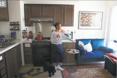  ?? Lea Suzuki / The Chronicle ?? Margie Talavera, who served in the Navy in the 1970s, stands in her kitchen with her dog, Little Bear.