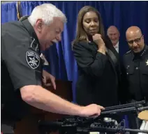  ?? TANIA BARRICKLO — DAILY FREEMAN ?? Ulster County Undersheri­ff Eric Benjamin, left, and Sheriff Juan Figueroa, right, show New York State Attorney General Letitia James the weapons that were obtained in the recent bust along with drugs.