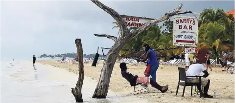  ??  ?? In this September 2014 file photo, persons who make a living in the resort area are seated on a beach in Negril. A Tourism Workers Pension Scheme is being created to better the lives of hospitalit­y workers in retirement. Parliament­ary debate is expected to begin on legislatio­n for the scheme in September 2018.