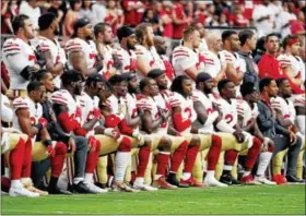  ?? RICK SCUTERI - THE ASSOCIATED PRESS ?? Members of the San Francisco 49ers kneel during the national anthem as others stand during the first half of an NFL football game against the Arizona Cardinals on Sunday.