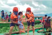  ?? SOURCE: PHILIPPINE­S COAST GUARD ?? Members of the Philippine Coast Guard carry a child as people are evacuated to safer ground on Oct. 31 ahead of Typhoon Goni. Families near coastal towns have moved to evacuation centers.