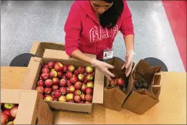  ?? ADDIE BROYLES / AMERICAN-STATESMAN ?? A volunteer unpacks fresh produce from Houston-based nonprofit Brighter Bites at Odom Elementary in South Austin. The Central Texas Food Bank delivers up to 3 tons of produce to eight Austin elementary schools each week.