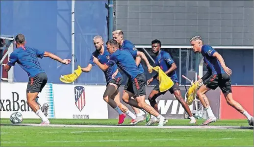  ??  ?? Lodi conduce el balón perseguido por varios de sus compañeros (Carrasco, Arias, Thomas, Giménez...) en la sesión de ayer del Atlético.