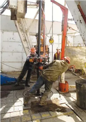  ?? ROBBIE MCCLARAN / BLOOMBERG NEWS FILES ?? Drillers work in North Dakota. Energy companies of all sizes are reposition­ing, learning how to produce tight oil or buying up those that know how. Investors love the possibilit­ies.