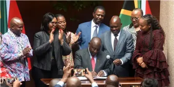  ?? ?? ▲ President Cyril Ramaphosa, joined by minister of health Dr Joe Phaahla, signing into law the National Health Insurance Bill which directs the transforma­tion of SA’s healthcare system to achieve universal coverage for health services.