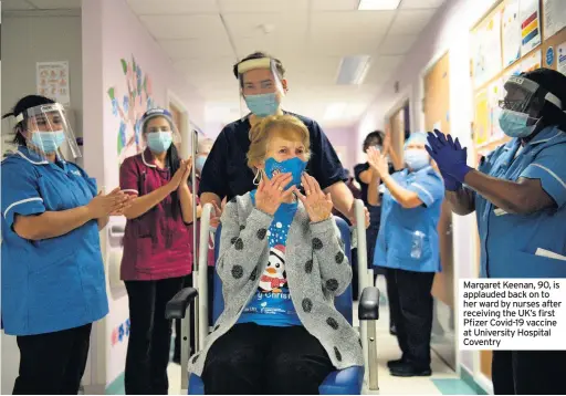  ??  ?? Margaret Keenan, 90, is applauded back on to her ward by nurses after receiving the UK’s first Pfizer Covid-19 vaccine at University Hospital Coventry