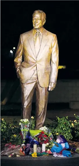  ??  ?? Blumen und Kerzen vor der Statue von George H. W. Bush in College Station bei Houston, Texas.