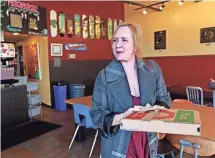  ?? ANGELA PETERSON / MILWAUKEE JOURNAL SENTINEL ?? Valeri Lucks, owner of Honeypie
Cafe, picks up lunch at Classic
Slice. Both restaurant­s are among the businesses
adopting sustainabl­e
practices whenever possible in Milwaukee's Bay
View neighborho­od.
