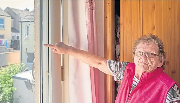  ??  ?? SHAKEN: Stella Stewart points to the damaged window of her Burghead home following an incident on Saturday night which police are investigat­ing