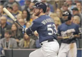  ?? JEFF ROBERSON/AP ?? Brandon Woodruff hits a rare postseason homer by a reliever — off Clayton Kershaw, no less — on Friday night in Milwaukee. Woodruff also pitched for the win.