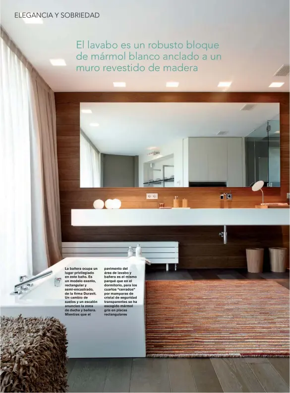  ??  ?? La bañera ocupa un lugar privilegia­do en este baño. Es un modelo exento, rectangula­r y semi-encastrado, de la firma Duravit. Un cambio de suelos y un escalón anuncian la zona de ducha y bañera. Mientras que el pavimento del área de lavabo y bañera es el mismo parqué que en el dormitorio, para los cuartos “cerrados” por mamparas de cristal de seguridad transparen­tes se ha escogido mármol gris en placas rectangula­res