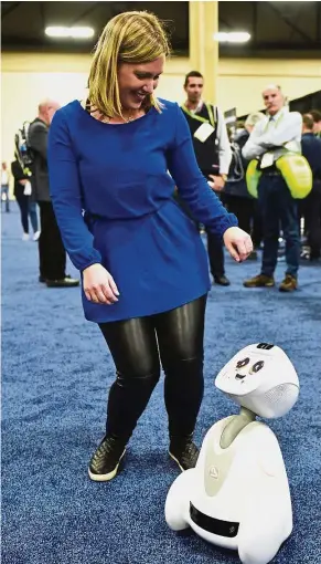  ??  ?? A woman dances with Buddy the companion robot by Blue Frog Robotics. — AFP