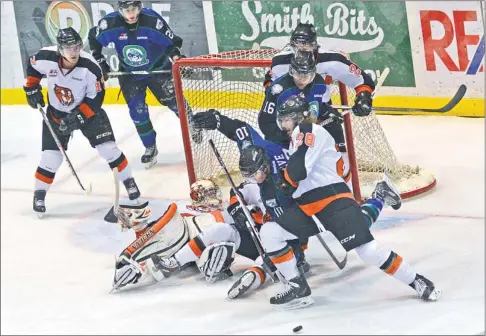  ?? Photo by Steven Mah ?? Broncos’ captain Colby Cave (centre) battled with Medicine Hat’s Jake Doty (right) during a wild first-period scramble in front of goaltender Marek Langhamer.