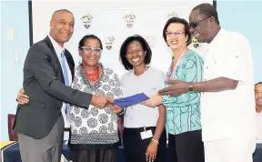  ??  ?? Courtney Betty (left), president and CEO, Timeless Herbal Care Ltd, presents his company’s scholarshi­p commitment document to recipients (from left) Dr Ellen CampbellGr­izzle, associate professor and former dean of the College of Health Sciences (COHS);...