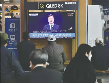  ?? JUNG YEON-JE / AFP VIA GETTY IMAGES ?? People watch a news broadcast of South Korean President Moon Jae-in speaking on the third anniversar­y of his
inaugurati­on at a railway station on Sunday in Seoul, where a burst of new coronaviru­s cases has emerged.