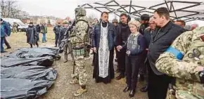  ?? EPA PIC ?? A handout photo by the Ukrainian Prime Minister's official Telegram channel showing European Commission President Ursula von der Leyen (second from right) looking at bodybags of civilians allegedly killed by Russian troops, during her visit to Bucha, Kyiv region, Ukraine, on Friday.
