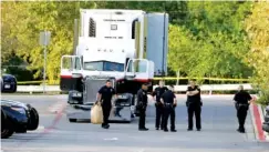  ?? THE ASSOCIATED PRESS ?? San Antonio police officers investigat­e the scene Sunday where eight people were found dead in a tractor-trailer loaded with at least 30 others outside a Walmart store in stifling summer heat in what police are calling a horrific human traffickin­g case.