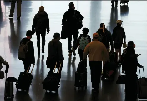  ?? RICK BOWMER — THE ASSOCIATED PRESS ?? Travelers walk through the Salt Lake City Internatio­nal Airport in Salt Lake City Nov. 25, a day before Thanksgivi­ng. On Dec. 2 the U.S. Centers for Disease Control and Prevention urged Americans to stay home over the upcoming holiday season and consider getting tested before and after if they do decide to travel.