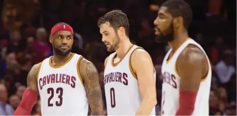  ?? JASON MILLER/GETTY IMAGES ?? LeBron James, left, Kevin Love, centre, and Kyrie Irving sat out the Cavaliers’ loss in Memphis on Wednesday, with coach Tyronn Lue opting to rest his high-scoring trio with Cleveland playing on consecutiv­e nights.
