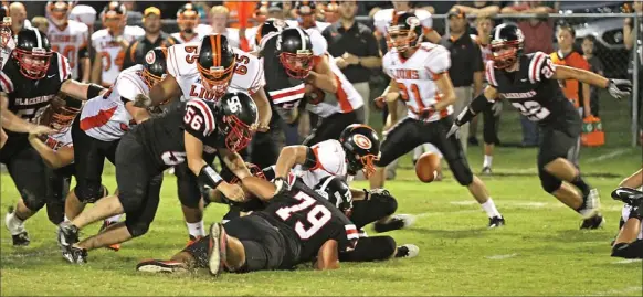  ?? Photograph courtesy of Russ Wilson ?? The ball flew up during a fumble Friday night in the contest between Gravette and Pea Ridge at Blackhawk Stadium. Blackhawk senior Braxton Caudill, No. 22, dives to recover the ball, as Tyler Handy, No. 79, makes a tackle.