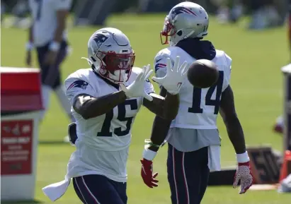  ?? AP PHotos ?? ‘BUILD CHEMISTRY’: Patriots wide receiver N'Keal Harry (15) makes a catch as wide receiver Mohamed Sanu Sr. (14) walks past during training camp in Foxboro on Tuesday.