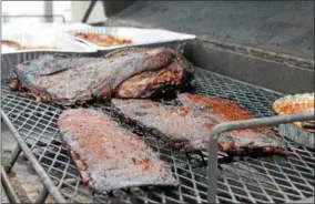  ?? FILE PHOTO ?? Barbecue meat cooks on a grill during a previous Troy Pig Out.