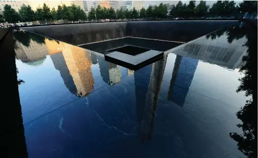  ?? (Alejandra Villa/Reuters) ?? FRIENDS AND family members gather at the 9/11 Memorial during ceremonies marking the anniversar­y of the 9/11 attacks on the World Trade Center in New York.