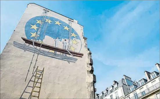  ?? JOEL SAGET / AFP ?? Trampantoj­o en un edificio de París que representa a dos personas pintando la bandera de Europa