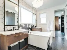  ??  ?? The ensuite master bathroom has twin vanities and a large soaker tub.