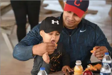  ?? ERIC BONZAR — THE MORNING JOURNAL ?? Lorain police Officer Reuben Figueroa and his 2-year-old son, Mikhael, enjoy lunch together during Live Healthy Lorain’s Rollin’ on the River initiative at Black River Landing on Sept. 28. The partnershi­p with Lorain County Health District, Lorain Port...