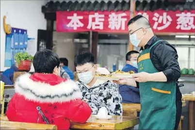  ?? ?? Camarero sirviendo comida en un restaurant­e en Pekín.