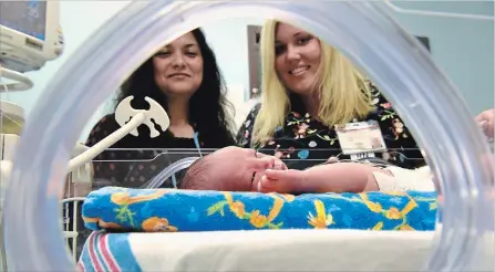  ?? STEVE HENSCHEL TORSTAR ?? New equipment, such as the “giraffe” isolette pictured here, means premature babies cared for by Niagara Health neonatal intensive care unit staff including Dr. Shiba Asim and registered nurse Lindsay Danielson can receive their care closer to home.