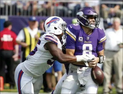  ?? BRUCE KLUCKHORN - THE ASSOCIATED PRESS ?? Minnesota Vikings quarterbac­k Kirk Cousins (8) fumbles as he is hit by Buffalo Bills defensive end Jerry Hughes, left, during the first half of an NFL football game, Sunday, in Minneapoli­s.