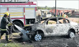  ?? Picture: EUGENE COETZEE ?? LOSING BATTLE: A fireman tries in vain to save a VW Polo which was set alight