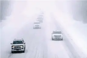  ?? Associated Press ?? ■ Cars drive on snow covered Interstate 495 North in nearly whiteout conditions Friday during a winter storm in Haverhill, Mass. Parts of New England are expected to receive about a foot of snow from the storm.