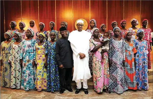  ??  ?? The president and his deputy with the 21 Chibok Girls rescued in October last year