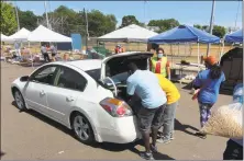  ?? Christian Abraham / Hearst Connecticu­t Media ?? Volunteer William Wildridge, right, helps load a car during a drive-thru food distributi­on event led by the Connecticu­t Food Bank in New Haven on June 25. The food bank is among the nonprofits that received PPP loans.