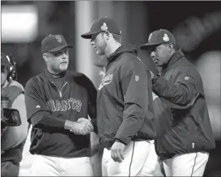  ?? Paul Kitagaki Jr.
/ Sacramento Bee / MCT ?? San Francisco Giants bench coach Ron Wotus ( eft) and batting coach Hensley Meulens, right, congratula­te starting pitcher Madison Bumgarner after a 2-0 win against the Detroittig­ers in Game 2 of the 2012 World Series at AT&T Park onthursday, Oct. 25, 2012, in San Francisco.