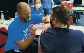  ?? COURTESY OF SAN JOAQUIN COUNTY OFFICE OF EDUCATION ?? Patrick McGar, a school nurse from Manteca Unified, gives a Covid-19 vaccine to a teacher during a vaccine clinic at the San Joaquin Office of Education on February 19.