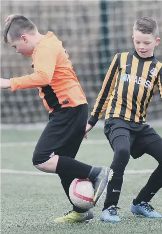  ??  ?? Russell Foster Mini Soccer Under-10s Winter League action between Dubmire Milan (orange) and Whitburn & Cleadon.