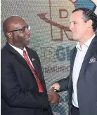  ??  ?? Gary Allen, CEO, RJRGLEANER Communicat­ions Group, shakes hands with Carlos Villares, CEO of Gustazos Internatio­nal.