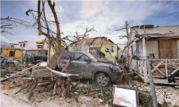  ?? FOTOS DPA(2)/REUTERS/AP ?? Auf der Karibikins­el Sint Maarten wurden viele Häuser zerstört. Zudem kommt es zu Plünderung­en. Bürger sind bewaffnet auf den Straßen unterwegs. Die niederländ­ische Marine nannte die Situation „besorgnise­rregend“.