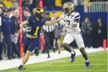  ?? AP PHOTO/DAVID J. PHILLIP ?? Michigan wide receiver Roman Wilson is pushed out of bounds by Washington cornerback Dominique Hampton on Monday during the national championsh­ip College Football Playoff game in Houston. The game ended after deadline. Readers can find more info online.