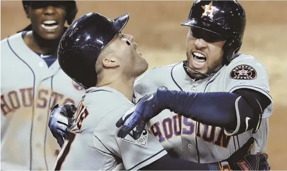  ?? AP PHOTO ?? TWO GOOD: George Springer celebrates with Jose Altuve after hitting a two-run homer in the 11th inning to lift the Astros past the Dodgers in Game 2 of the World Series last night in Los Angeles.